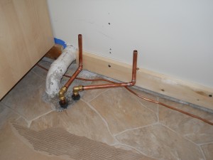 Newly placed plumbing before the sink cabinet goes in